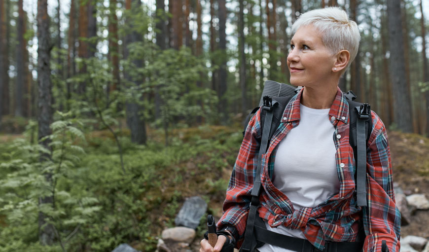 mujer adulta disfrutando feliz de un paseo en el bosque